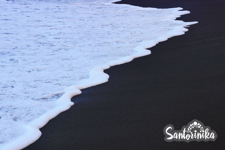 Sea surf on the black beach of Perissa, Santorini, Greece